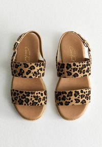 Sandaler med leopardmönster, två breda tygremmar, en spänne vid vristen och en vadderad innersula. Lätt och flexibel sula.