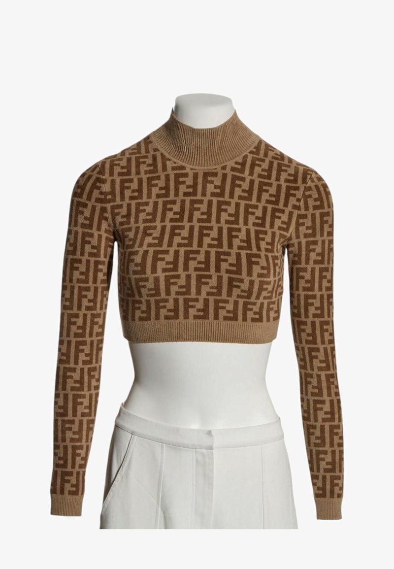 Pull court marron à col roulé avec motif géométrique marron foncé répété et manches longues sur un torse de mannequin blanc.