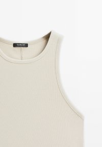 Světlý béžový žebrovaný top bez rukávů s kulatým výstřihem a širokými ramínky. Nálepka uvnitř nese nápis "Massimo Dutti." Hladká textura, přiléhavý střih.