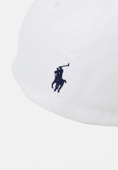 Witte baseballpet van katoen, met een blauw geborduurd logo van een polo speler aan de voorkant. Rond vizier met gestikt detail.