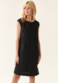 Schwarzes Leinen-Kleid ohne Ärmel mit geradem Schnitt, knielang, featuring minimalen Nähten und rundem Halsausschnitt. Glatte Textur ohne Muster.