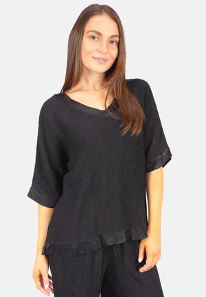 Schwarze Bluse aus strukturiertem Stoff mit V-Ausschnitt, überschnittenen Ärmeln und Satinbesatz an den Kanten. Sie hat einen lässigen Schnitt und einen geschichteten Saum.