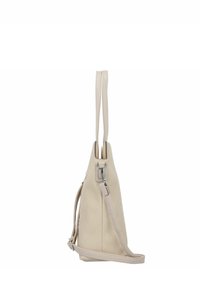 Beige canvas tas met twee lange leren handvatten, een ritsluiting en een afneembare schouderband. Heeft een gestructureerde, driehoekige vorm.