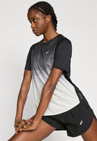 Μαύρο και γκρι αθλητικό πουκάμισο με κοντά μανίκια, βαθμιαίο μοτίβο και λογότυπο, συνδυασμένο με μαύρο σορτς, απαλό ύφασμα και άνετη εφαρμογή.