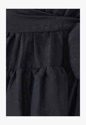 Schwarzes Kleid aus einem strukturierten Stoff mit einem subtilen Glanz, in der Taille gerafft und mit gestuften Lagen für eine fließende Silhouette.