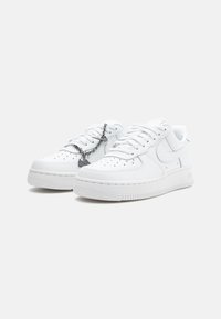 Hvite lær sneakers med perforert tåboks, flate lisser og gummisåler. Har en kjedeaccent på lissene og en logo på siden.