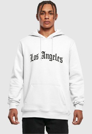 White hoodie with "Los Angeles" in large black script on the front, featuring a kangaroo pocket and ribbed cuffs.