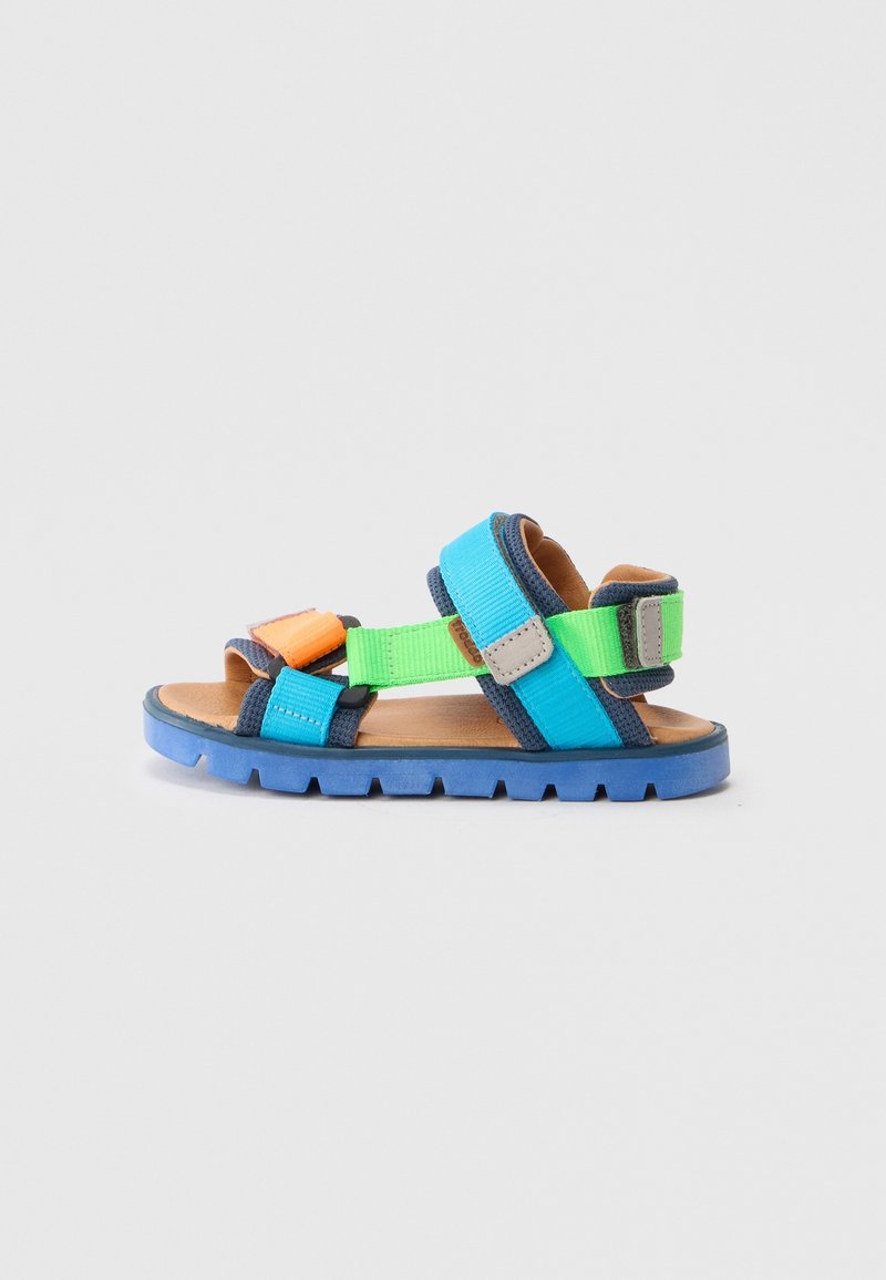Sandale enfant à bout ouvert avec semelle bleue et brides en bleu, vert et orange, équipée de fermetures ajustables à scratch sur fond clair.