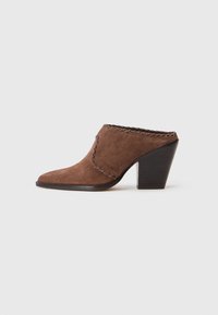 Mules de ante marrón con tacón, punta afilada, costuras decorativas a lo largo del borde y un tacón de madera gruesa.