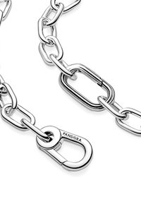 Strieborný reťazový náramok s veľkými oválnymi článkami, s prackou s vyrytým nápisom "PANDORA" a lesklým povrchom.