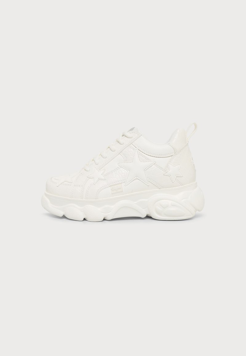 Λευκό chunky sneaker με αστέρι σχήματος σχέδια και παχιά υφή σόλα, που φαίνεται από την εξωτερική πλευρά σε ένα απλό φόντο.