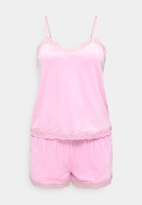 Ensemble de camisole et short en satin rose pâle avec bordure en dentelle sur l'encolure, l'ourlet et les bords du short, présenté sur un fond clair uni.