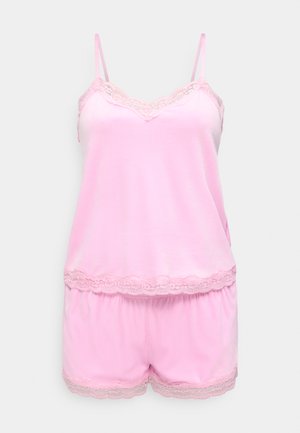 Miękki różowy komplet satynowy z koszulką na ramiączkach i szortami, wykończony koronką na dekolcie, krawędzi bluzki i szortów, przedstawiony na jednolitym jasnym tle.
