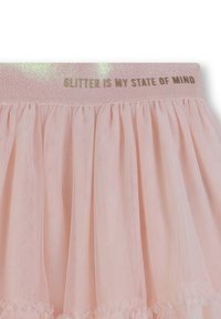 Jupe en tulle rose avec une taille pailletée arborant le texte "LES PAILLETTES SONT MON ÉTAT D'ESPRIT." Texture douce, design en couches, ourlet festonné.