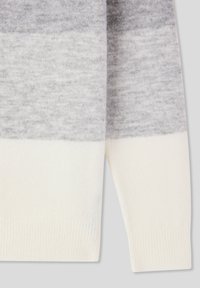 Jasnoszary sweter w białe paski o miękkiej fakturze, z prążkowanymi mankietami i gradientowym wzorem przechodzącym od ciemniejszych do jaśniejszych odcieni.