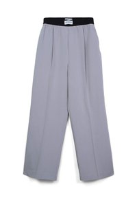 Pantalons larges gris clair avec ceinture élastique noire et plis, posés à plat sur un fond blanc.