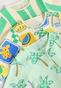 Tre ribbade bodysuits i mjuk bomull: gröna och beige ränder, gula och blå fruktmönster samt mintgrön med palmträdsmönster.
