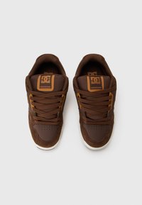 Brown sneakers made of textured fabric and suede. Features round toe, flat laces, padded collar, and logo accents on the tongue.