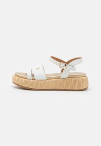 White sandal with two wide straps, adjustable ankle strap, and a woven-style platform sole in tan with a subtle embossed logo accent.