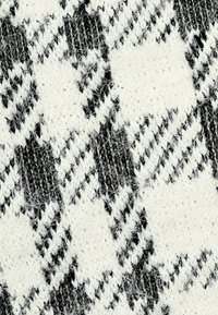 Schwarz-weißes Gewebe mit strukturiertem Muster, das große weiße Formen enthält, die mit dünnen schwarz-weißen Streifen durchsetzt sind. Weiche Textur.