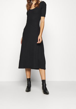 Robe midi noire avec un décolleté arrondi et des manches courtes, présentant un tissu côtelé texturé et une partie supérieure ajustée se transformant en une jupe évasée.