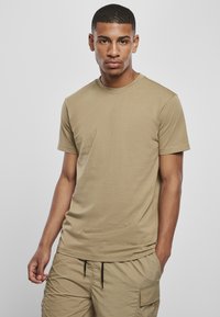 Khaki kortermet t-skjorte laget av lett bomull, med rund hals og en glatt tekstur. Kombinert med matchende cargo-shorts.
