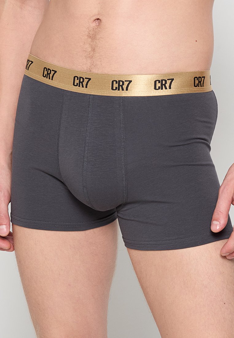 Graue Boxershorts mit einem goldenen elastischen Bund, der das "CR7"-Logo zeigt. Hergestellt aus glattem Stoff, entworfen für eine enganliegende Passform mit einem mittelhohen Bund.