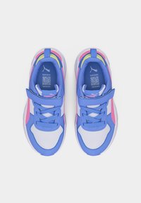 Ζευγάρι παιδικά αθλητικά παπούτσια Puma σε μπλε, άσπρο και ροζ, με λάστιχα Velcro, κορδόνια και κωδικούς QR στις εσωτερικές σόλες, εμφανιζόμενα από ψηλά.