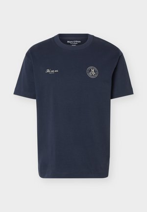 Μπλε σκούρο T-shirt με κοντά μανίκια και στρογγυλή λαιμόκοψη, με τη φράση «It’s on us. Since 1967» στο αριστερό στήθος και κυκλικό λογότυπο Marc O’Polo στο δεξί στήθος.