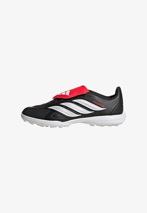 Scarpa da calcio Adidas Predator in bianco e nero con linguetta rossa e suola bianca con piccoli tacchetti.