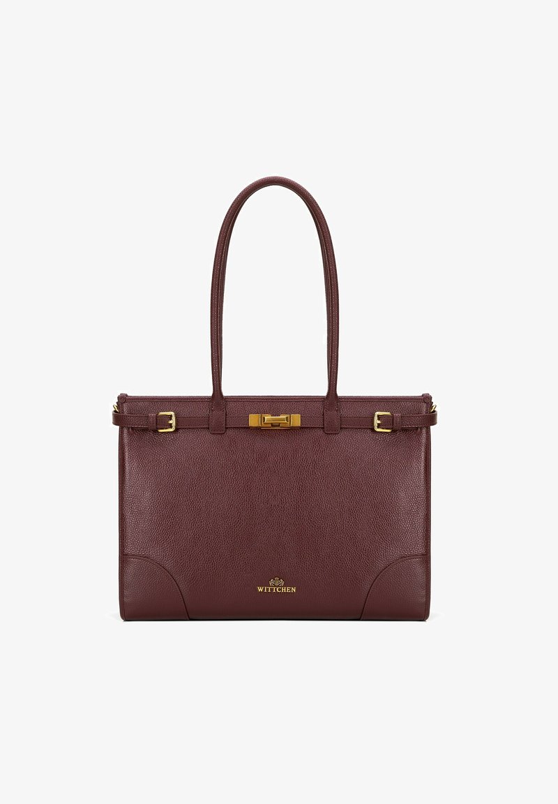 Bordowa skórzana torebka z podwójnymi uchwytami, złotymi akcentami i wyraźnym kształtem. Posiada zapięcie na klamrę oraz dekoracyjne przeszycia.