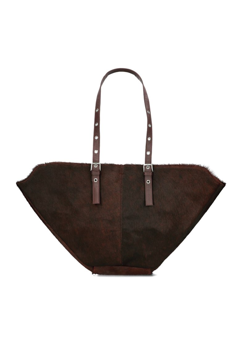 Sac fourre-tout en cuir marron avec une forme triangulaire large et distinctive, présentant une texture en fourrure, des doubles poignées et des accessoires en métal argenté.