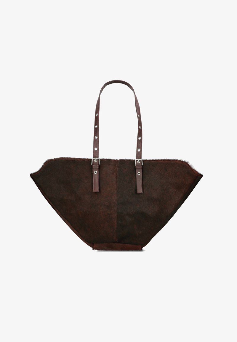 Sac fourre-tout en cuir marron avec une forme triangulaire large et distinctive, présentant une texture en fourrure, des doubles poignées et des accessoires en métal argenté.