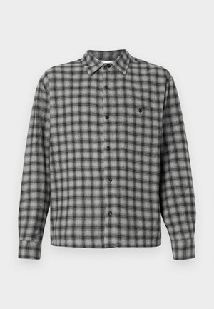 Camicia a quadri nera e grigia con maniche lunghe, colletto e bottoni neri. Il tessuto appare testurizzato con un motivo intrecciato.
