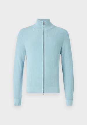 Hellblauer, gerippter Pullover mit hohem Kragen und einem Reißverschluss vorne. Verfügt über lange Ärmel und eine enganliegende Passform an Bündchen und Saum.