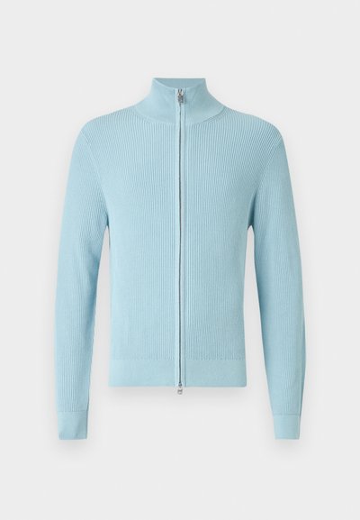 Ανοιχτό μπλε ριμπ πλεκτό πουλόβερ με ψηλό γιακά και εμπρόσθιο φερμουάρ. Διαθέτει μακριά μανίκια και εφαρμοστή γραμμή στους καρπούς και τη μέση.