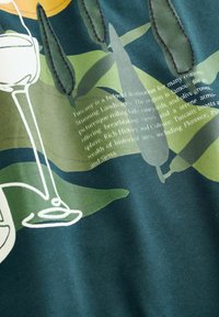 Grafika zobrazujúca tmavozelenú látku s hladkou textúrou. Dizajn obsahuje abstraktné olivové vetvičky, poháre na víno a textové prvky v svetlejších farbách.