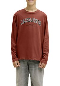 T-shirt à manches longues de couleur rouille en tissu doux avec un col rond. Présente "JACK & JONES" imprimé en texte noir gras sur la poitrine.