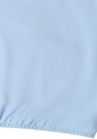 Tissu bleu clair avec de petits points texturés subtils et un ourlet élastique sur le bord inférieur.