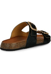 Sandal in pelliccia nera con suola in sughero, doppie cinghie con fibbie decorative simili all'oro e fondo testurizzato per il comfort.