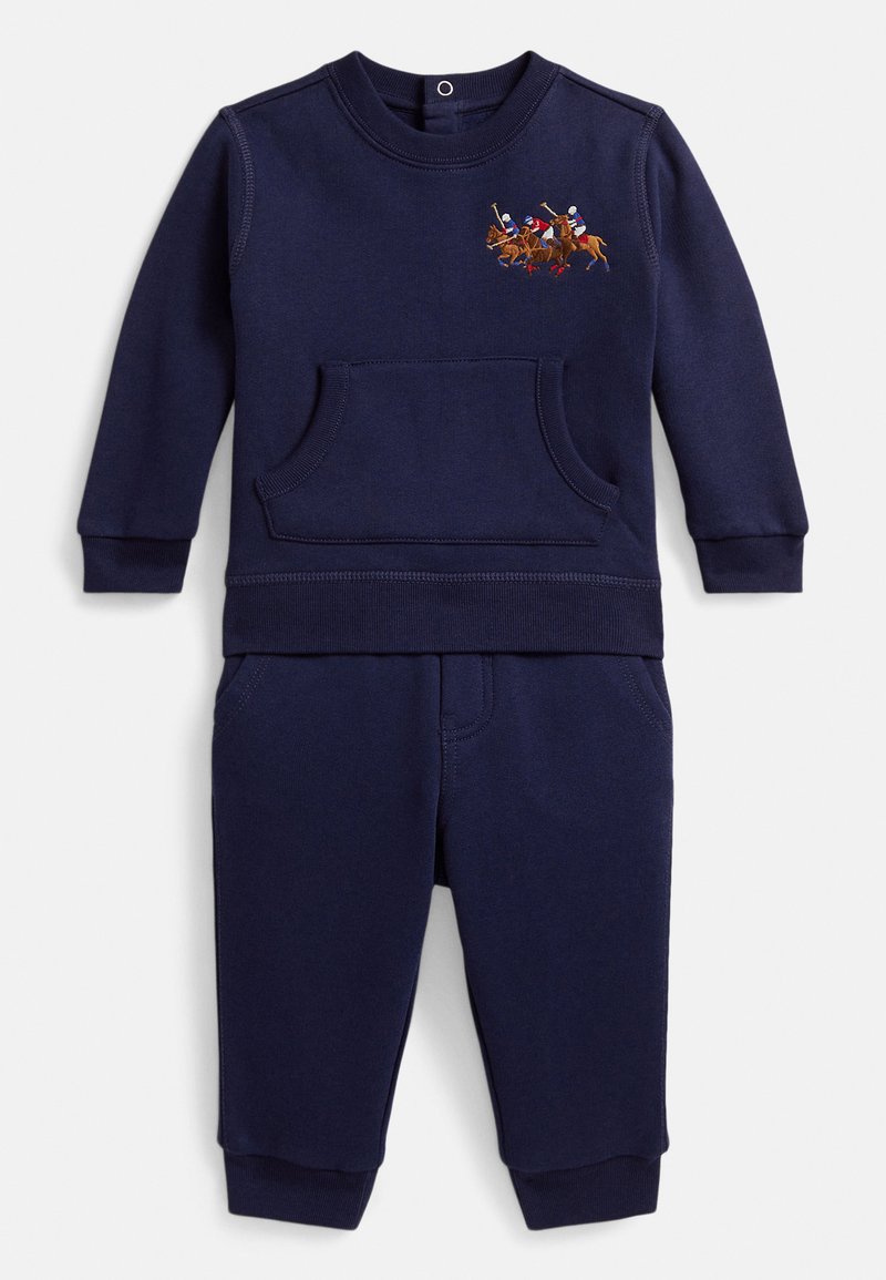 Σετ παιδική μπλούζα φούτερ και παντελόνι σε σκούρο μπλε με μπροστινή τσέπη και κεντημένους παίκτες πόλο στο αριστερό στήθος της μπλούζας.