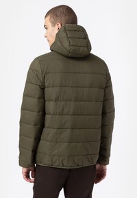 Olivgrön puffjacka med horisontell quiltad design, avtagbar huva och slät textur. Har en avslappnad passform och elastiska ärmslut.