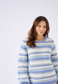 Pullover a righe blu chiaro e crema, con una texture a maglia, dalla vestibilità ampia e scollatura rotonda, con modelli a traforato in tutto il capo.