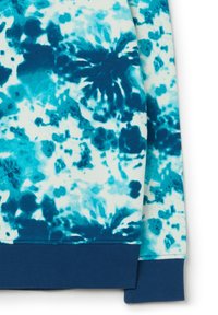 Sudadera azul con efecto tie-dye que combina tonos de azul claro y oscuro. Presenta un puño de punto en color marino en la parte inferior. Tejido suave y texturizado.