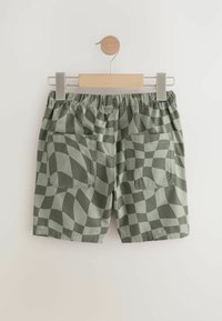 Shorts à carreaux verts avec une taille élastique, deux poches arrière et un tissu léger et lisse.