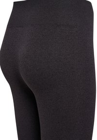 Czarne prążkowane legginsy z wysokim stanem, wykonane z teksturowanej tkaniny, o dopasowanym kroju, z naciskiem na tylny design i kontury.