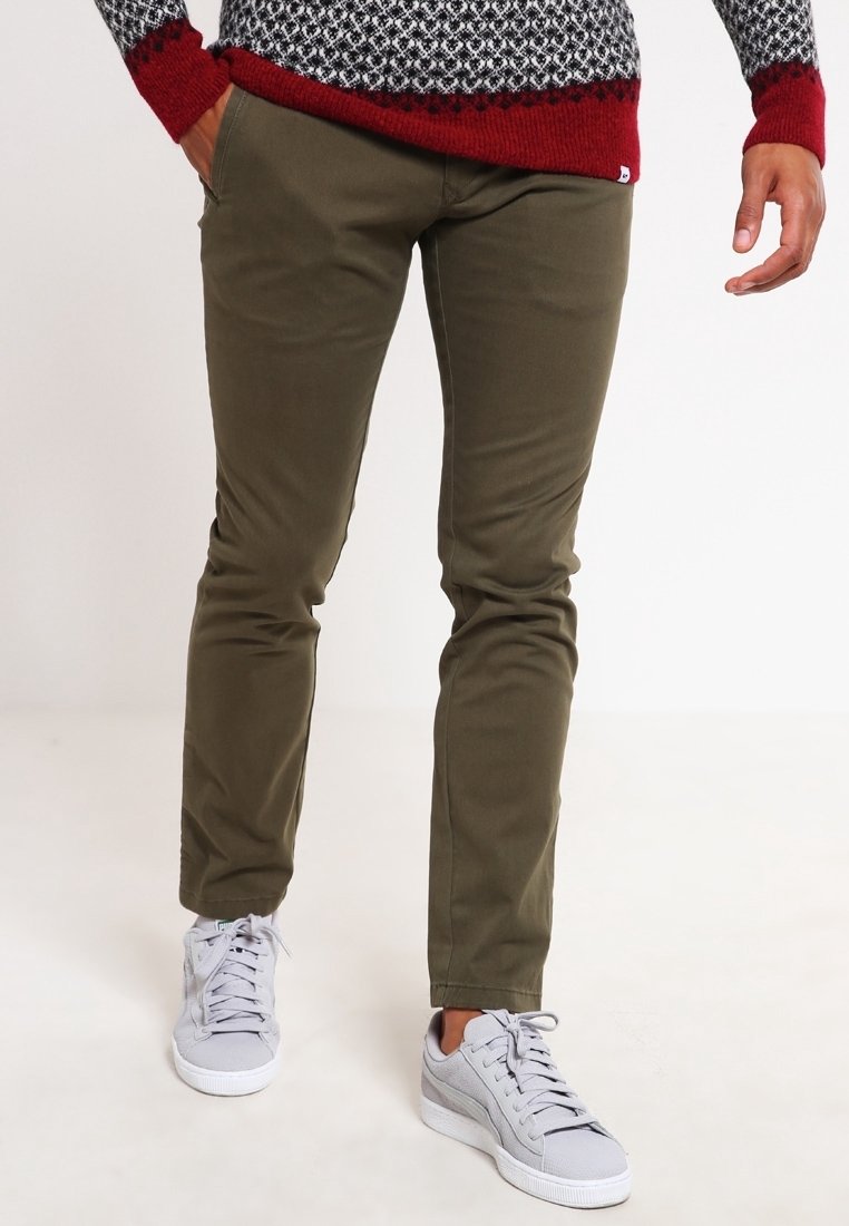 Olivgrüne Slim-Fit-Hosen aus Baumwollmischung, mit glatter Textur und normalen Taschen, getragen mit hellgrauen Sneakers.