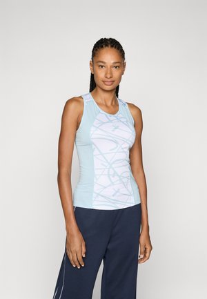 Canottiera sportiva azzurro chiaro con un motivo geometrico bianco, design senza maniche e una texture liscia. Abbinata a pantaloni blu scuro.