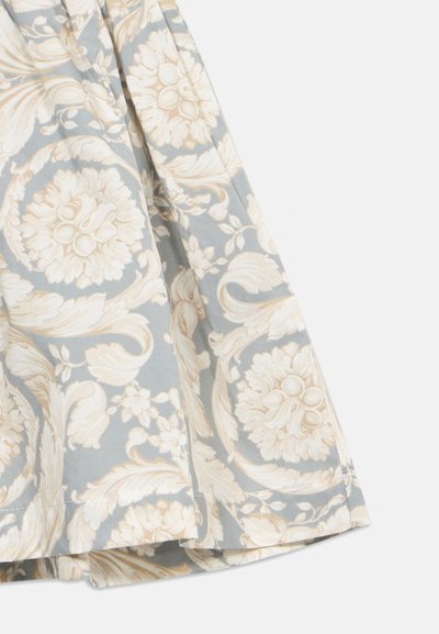 Ύφασμα με απαλό γαλάζιο φόντο και περίτεχνο κρεμ λουλουδένιο και φυλλώδες μοτίβο, με ορατές ραφές στο τελείωμα.