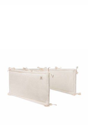 Coussins de protection en coton pour lit de bébé de couleur crème neutre, présentant un tissu texturé avec de petits points et des extrémités à nouer pour un maintien sécurisé.